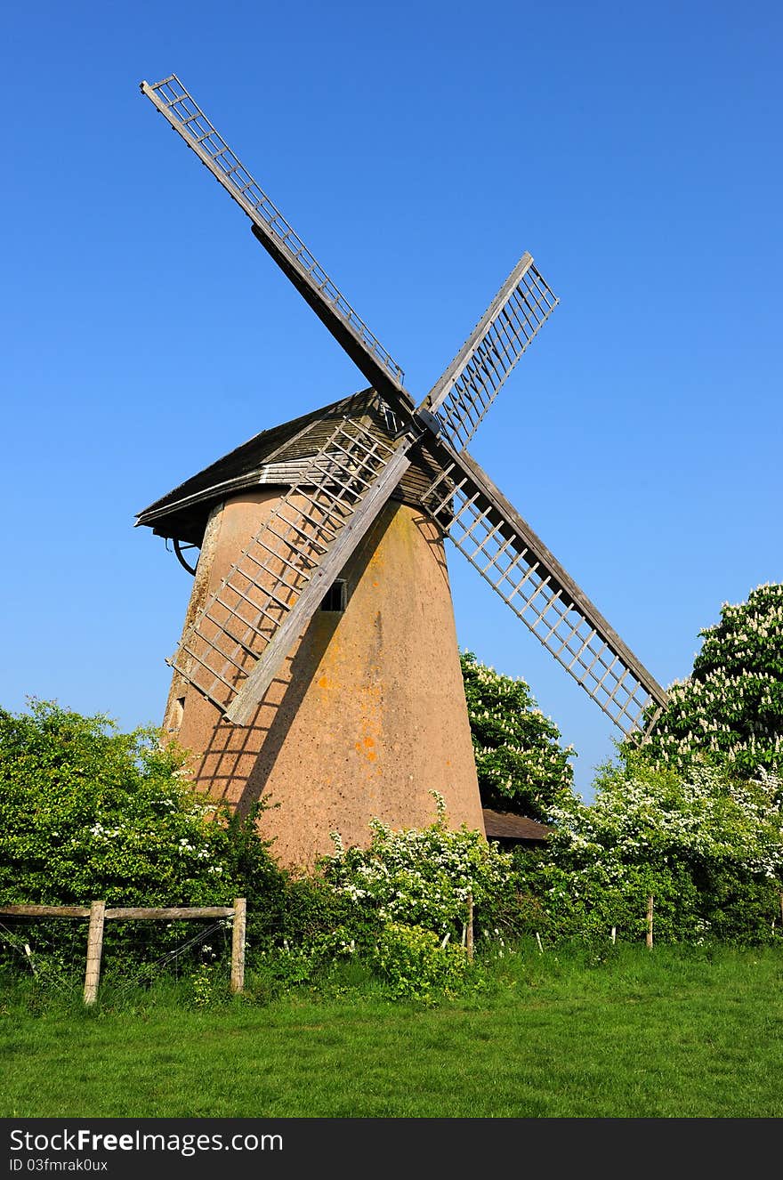 An old 17th century windmill against a clear blue sky. An old 17th century windmill against a clear blue sky