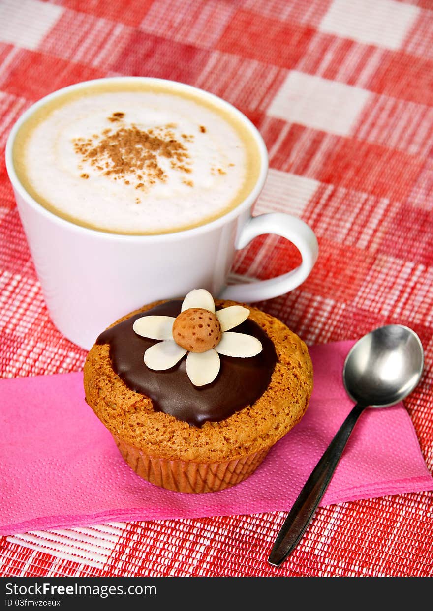 Breakfast concept: muffin, cup of coffee and spoon