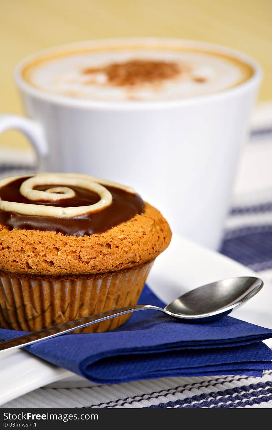 Breakfast concept: muffin, cup of coffee and spoon