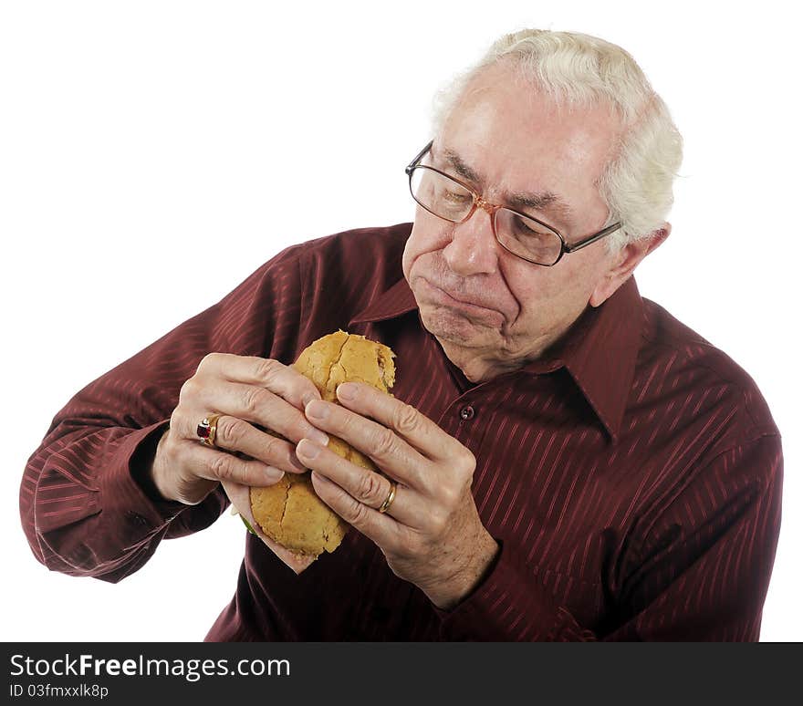 A senior man enjoying a big bite off his submarine sandwich. A senior man enjoying a big bite off his submarine sandwich.