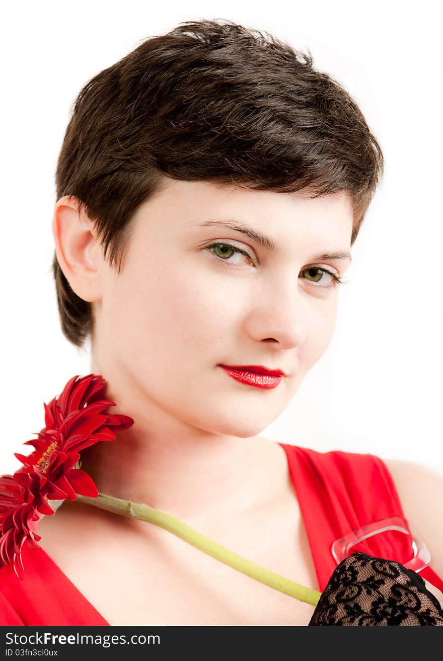 Brunette beauty portrait in red with red gerbera on white background. Brunette beauty portrait in red with red gerbera on white background