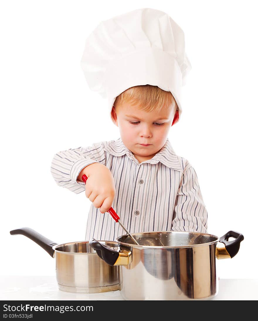 A funny cute boy is portraying a cook. isolated on a white background. A funny cute boy is portraying a cook. isolated on a white background