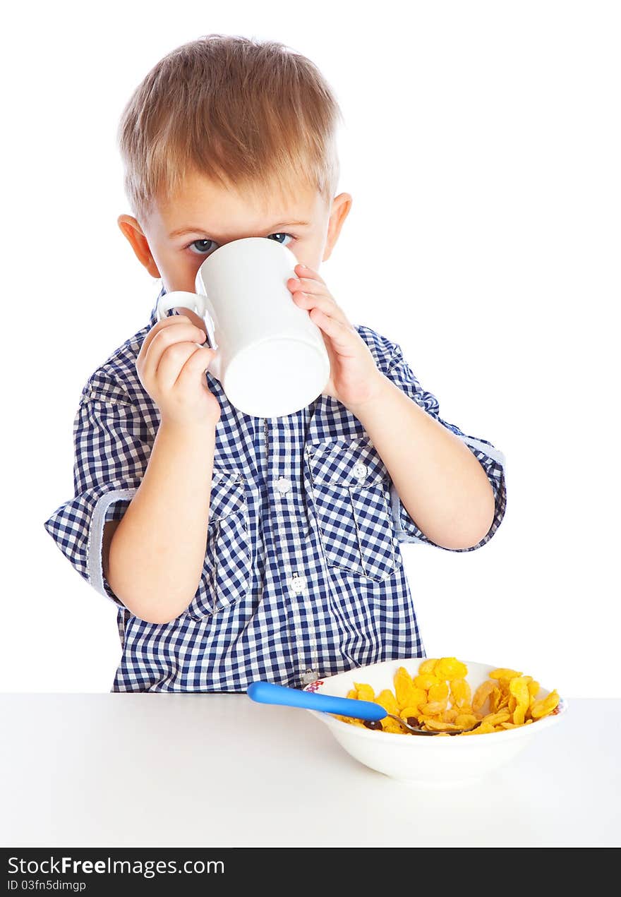 A boy is drinking milk and eating cereal from a bowl. Isolated on a white background. A boy is drinking milk and eating cereal from a bowl. Isolated on a white background