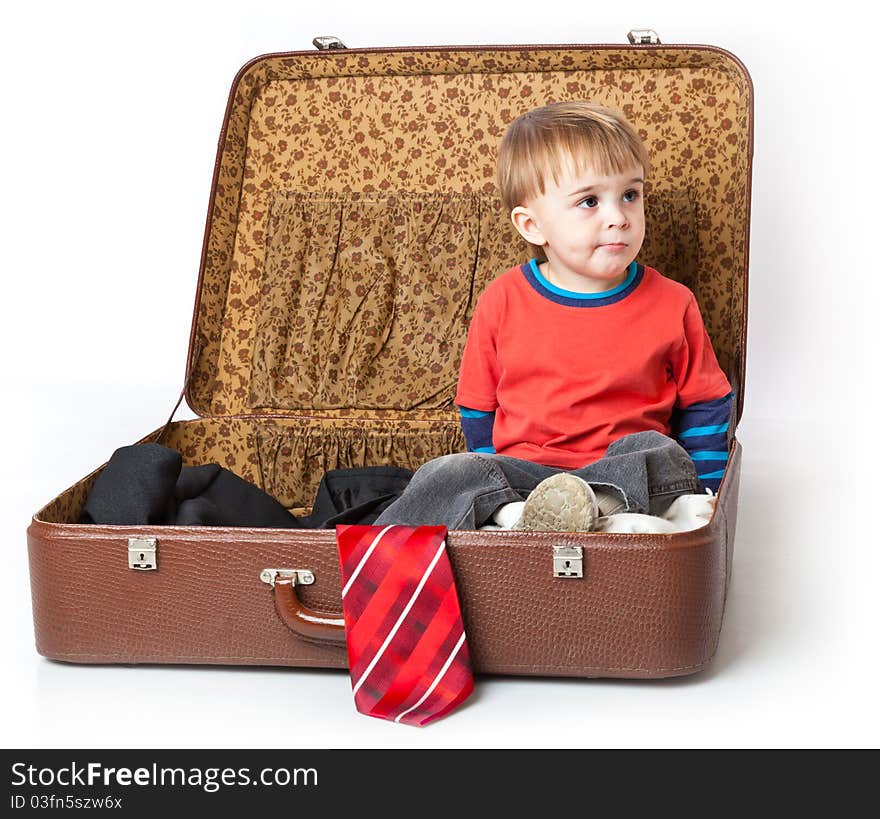 A funny boy in a suitcase. Isolated on a white background