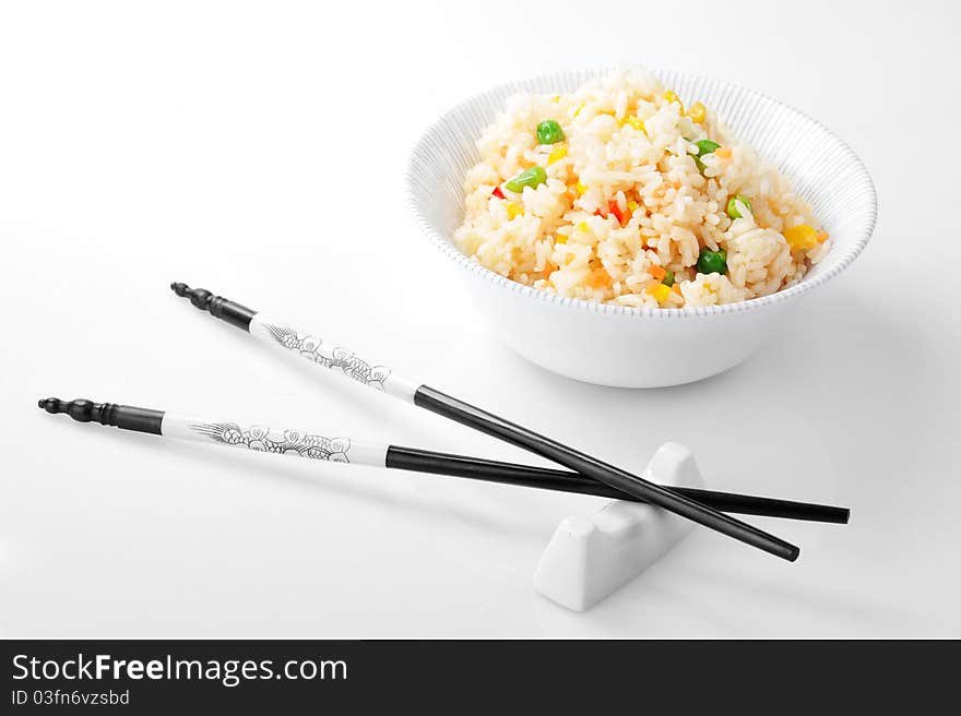 Bowl with rice and chopsticks close up