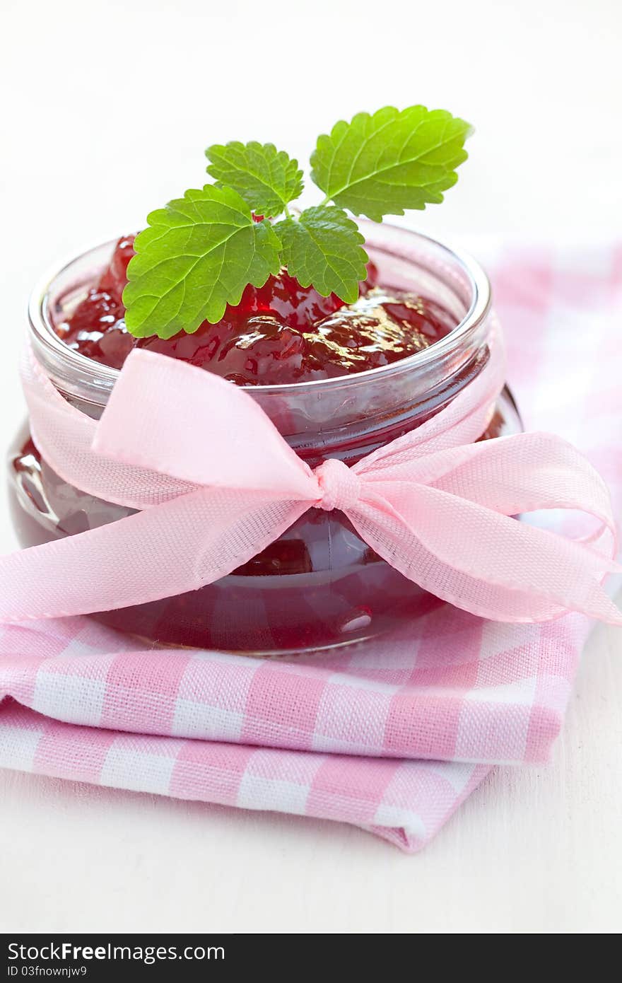 Fresh strawberry jam in a jar with ribbon