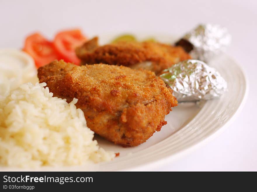 Chicken drumsticks and rice vegetables on white dish. Chicken drumsticks and rice vegetables on white dish