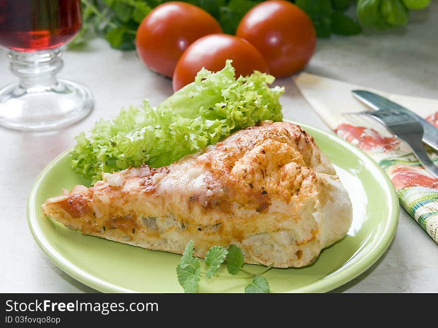 Tasty piece of pizza on a plate next to the fresh tomatoes. Tasty piece of pizza on a plate next to the fresh tomatoes