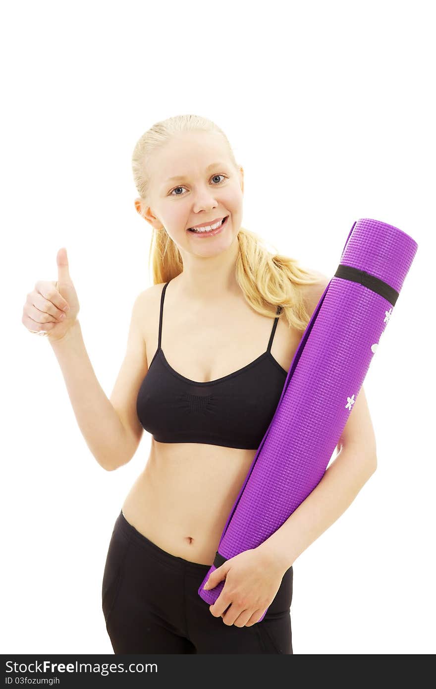 Happy beautiful sport girl standing with thumb up and holding purple mat in black clothes. Happy beautiful sport girl standing with thumb up and holding purple mat in black clothes.