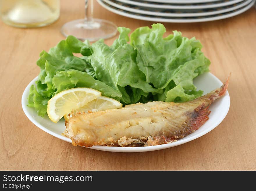 Fried red-fish with salad and lemon