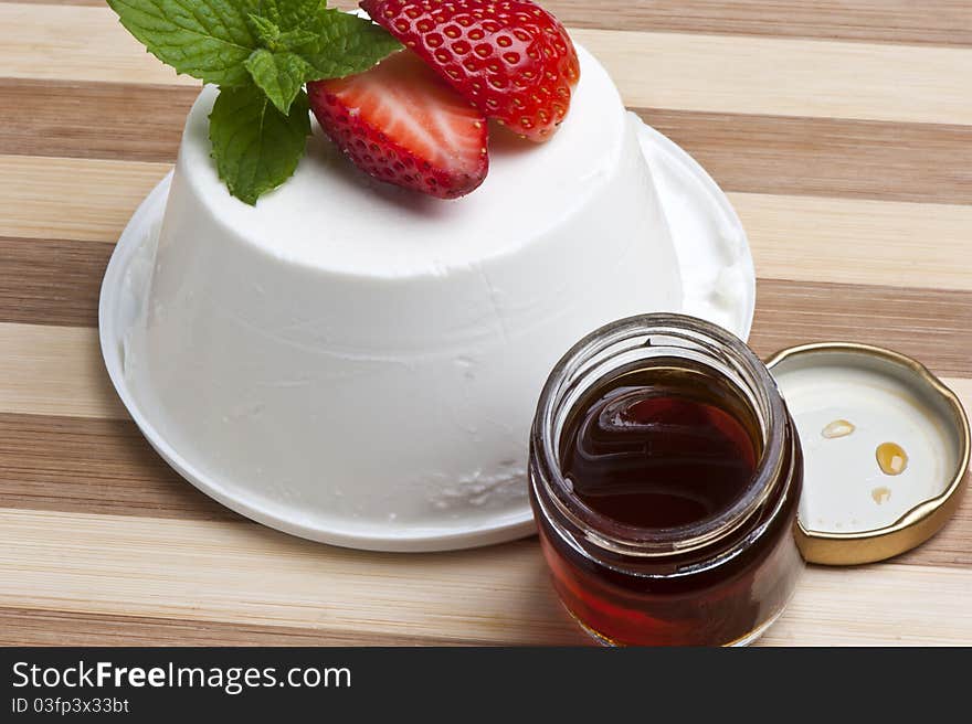 Cottage cheese decorated with strawberries and mint leaves and a jar of honey. Cottage cheese decorated with strawberries and mint leaves and a jar of honey