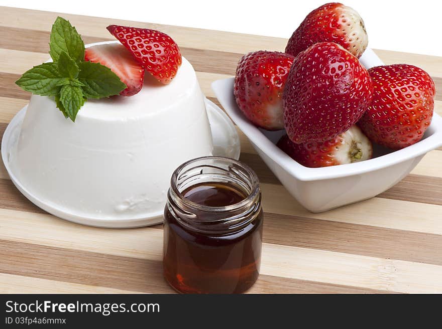 Cottage cheese decorated with strawberries and mint leaves and a jar of honey. Cottage cheese decorated with strawberries and mint leaves and a jar of honey