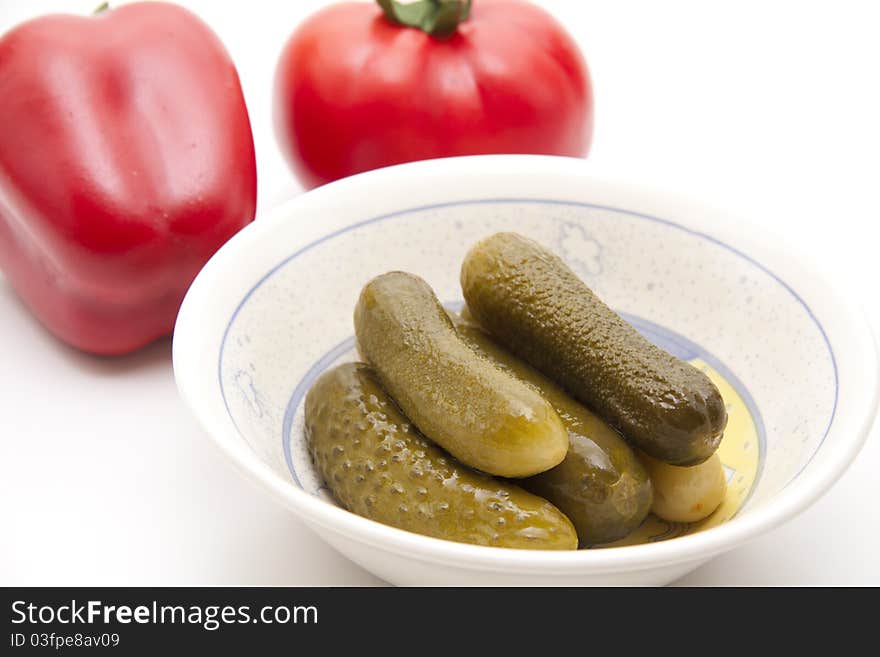 Gherkins in the bowl with tomato and paprikas