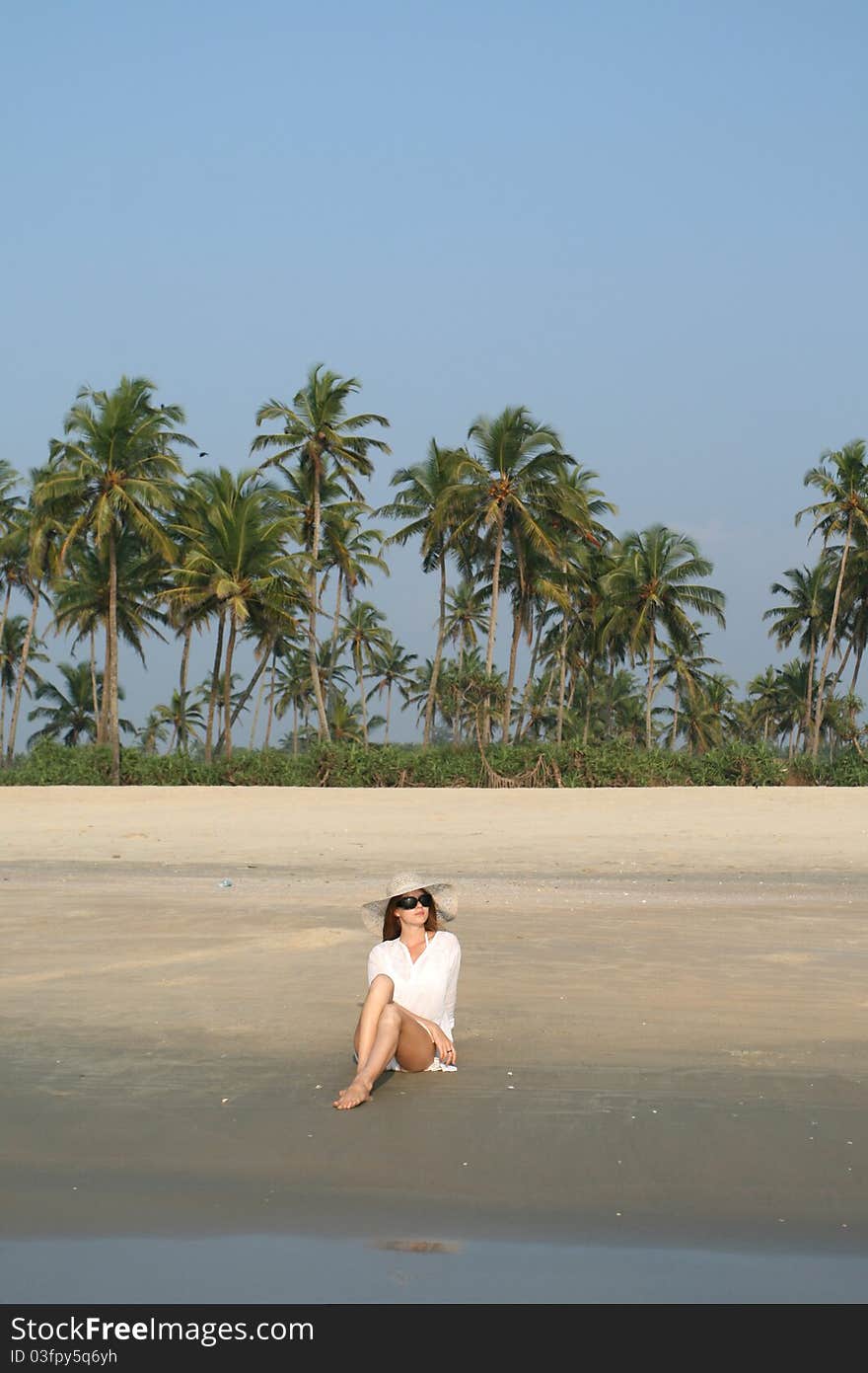 Woman in white hat lying on the beach in tropical country. Woman in white hat lying on the beach in tropical country