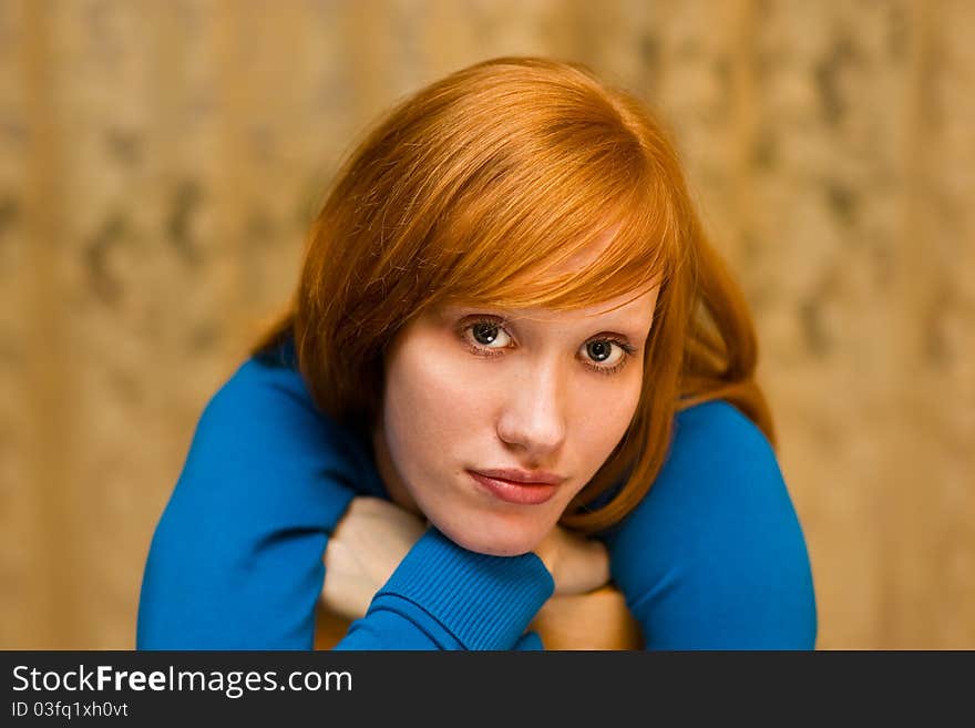 Young girl with red hair and sad eyes looking at us. Young girl with red hair and sad eyes looking at us