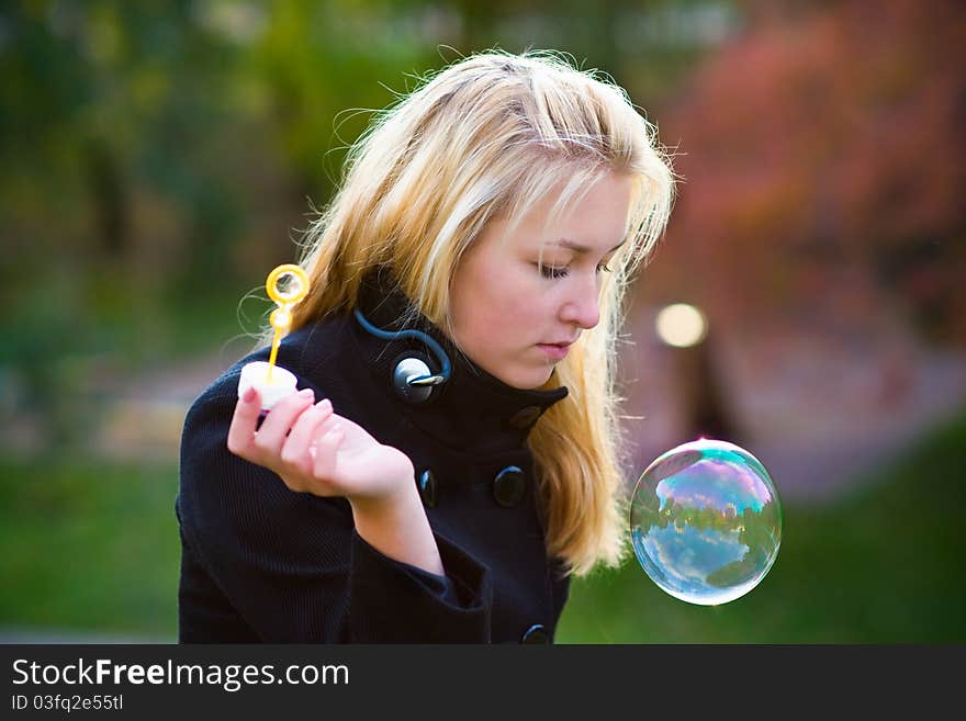 Teen girl looking at a large multi-colored bubbles, which gradually descends. Teen girl looking at a large multi-colored bubbles, which gradually descends