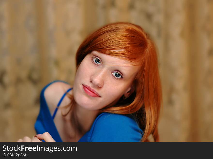 Young girl with red hair and sad eyes looking at us. Young girl with red hair and sad eyes looking at us