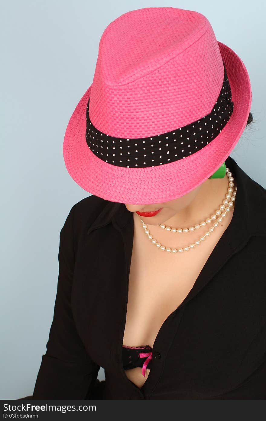 Brunette female wearing a pink hat and green earrings