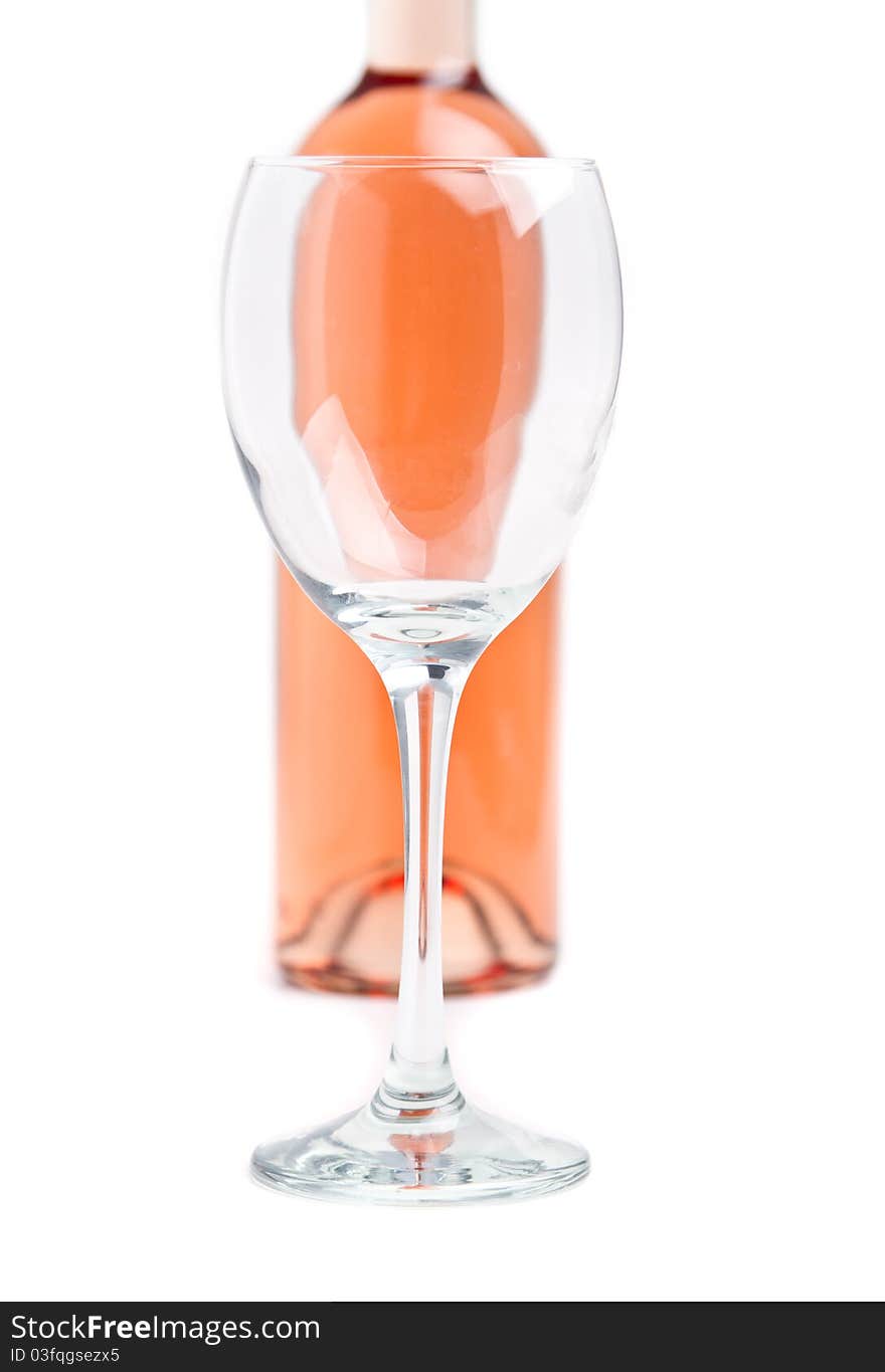 Rose wine in unmarked bottle with an empty glass in focus