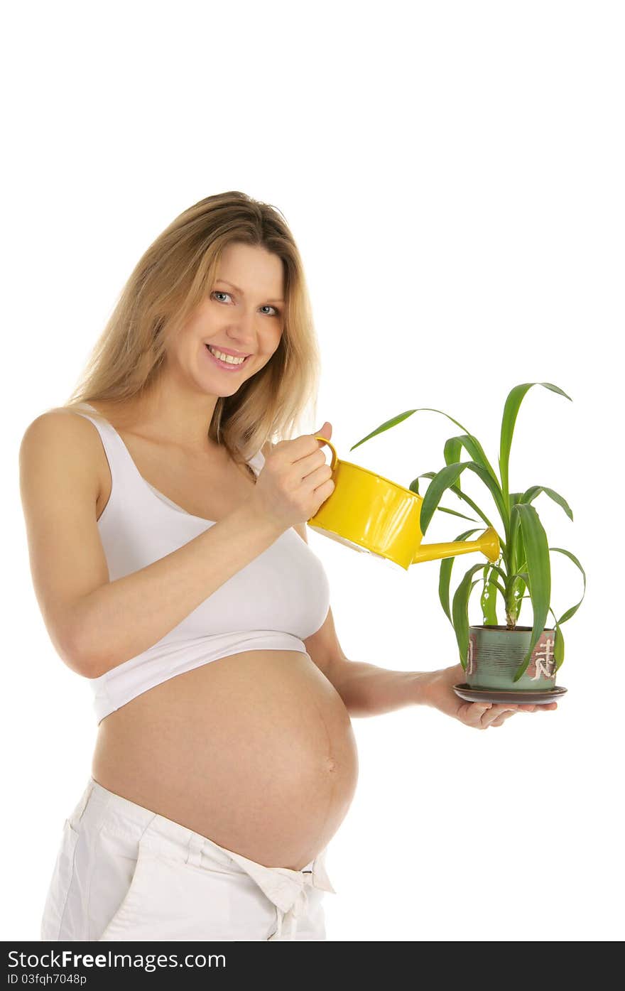 Pregnant woman watering the plant