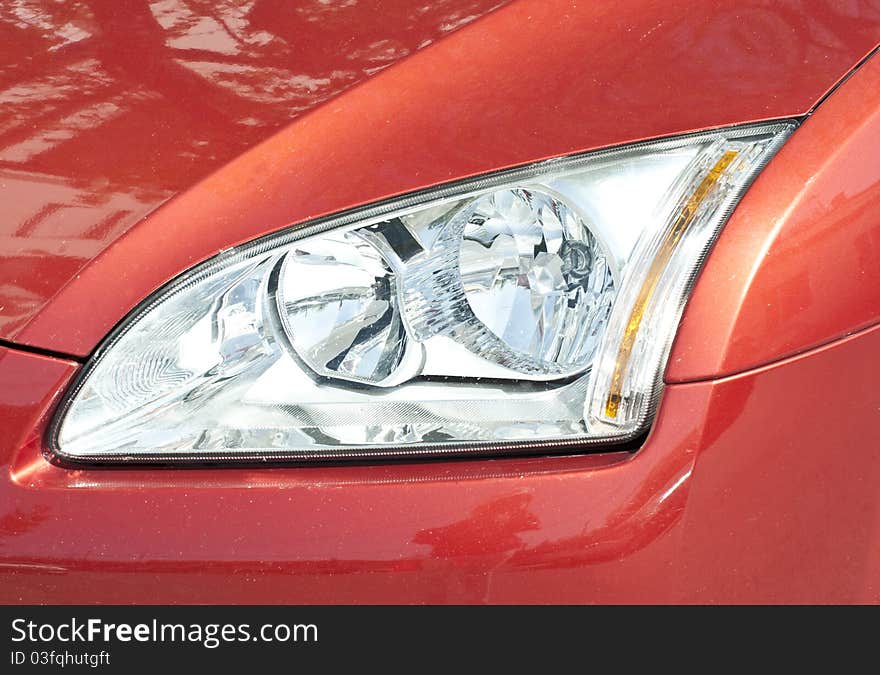 Red car headlight close up shot. Red car headlight close up shot