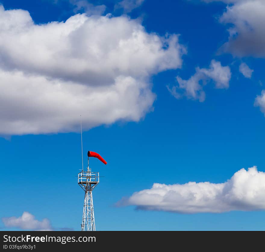 Bright Windsock Against a Vivid Blue Sky and Fluffy White Clouds