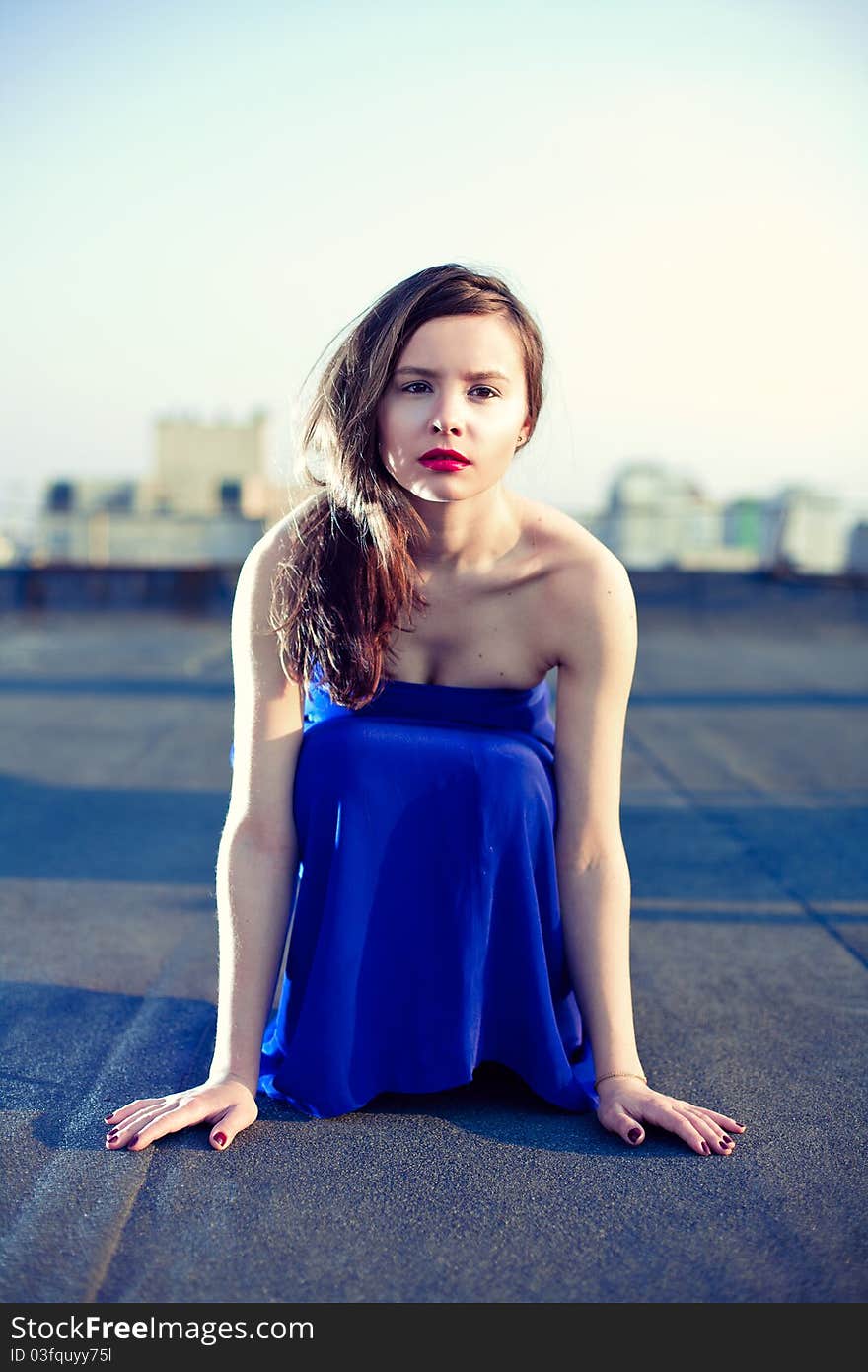 Attractive Girl Sitting In A Blue Dress