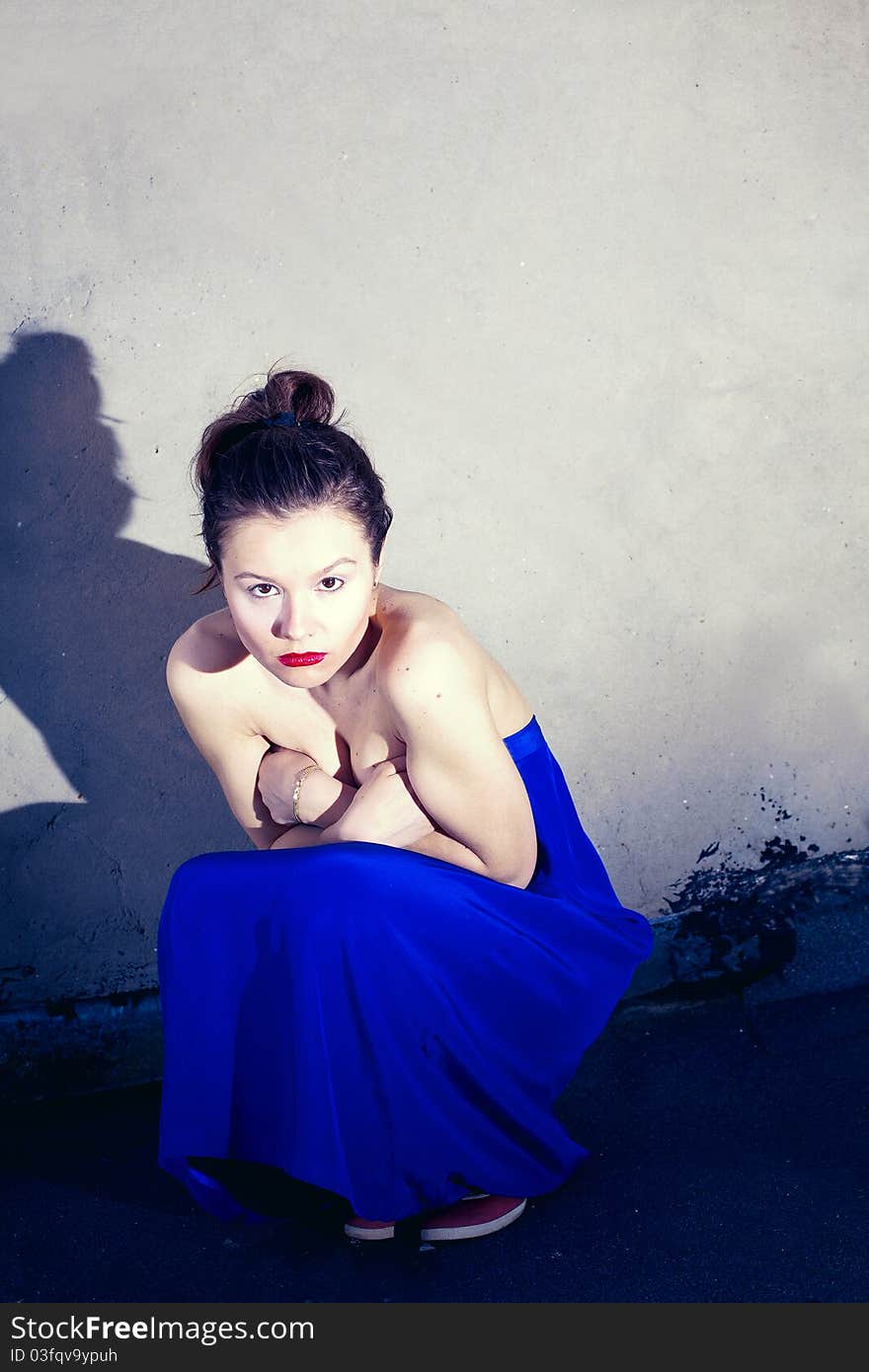 Glamour type photo of cute brunette sitting on the city bridge