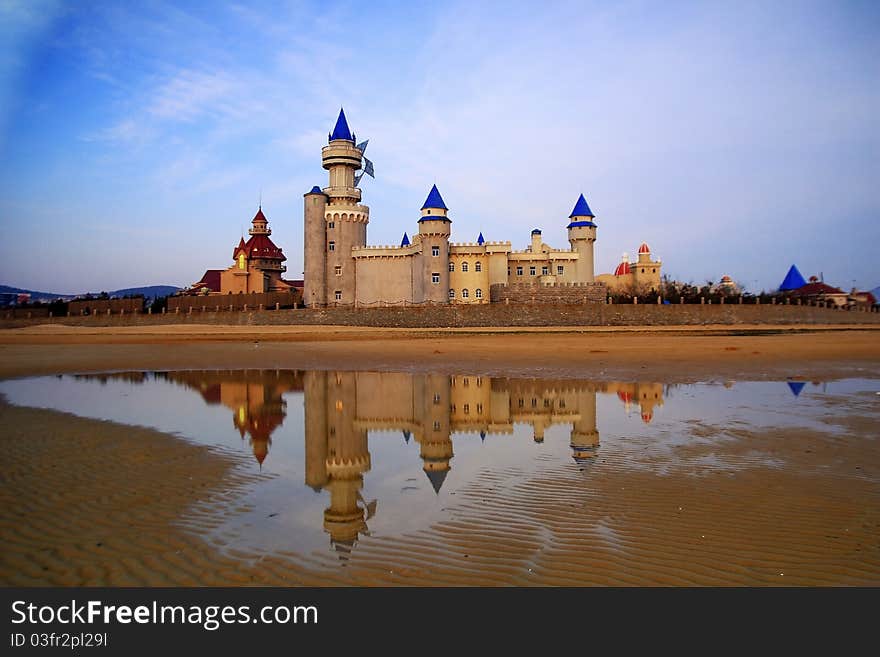 Shooting base of CCTV's colomn big pinwheel, set of castles on the beach with reflection. Shooting base of CCTV's colomn big pinwheel, set of castles on the beach with reflection