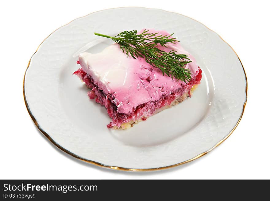 Layered salad of herring, potatoes, beets and mayonnaise on plate isolated on white background