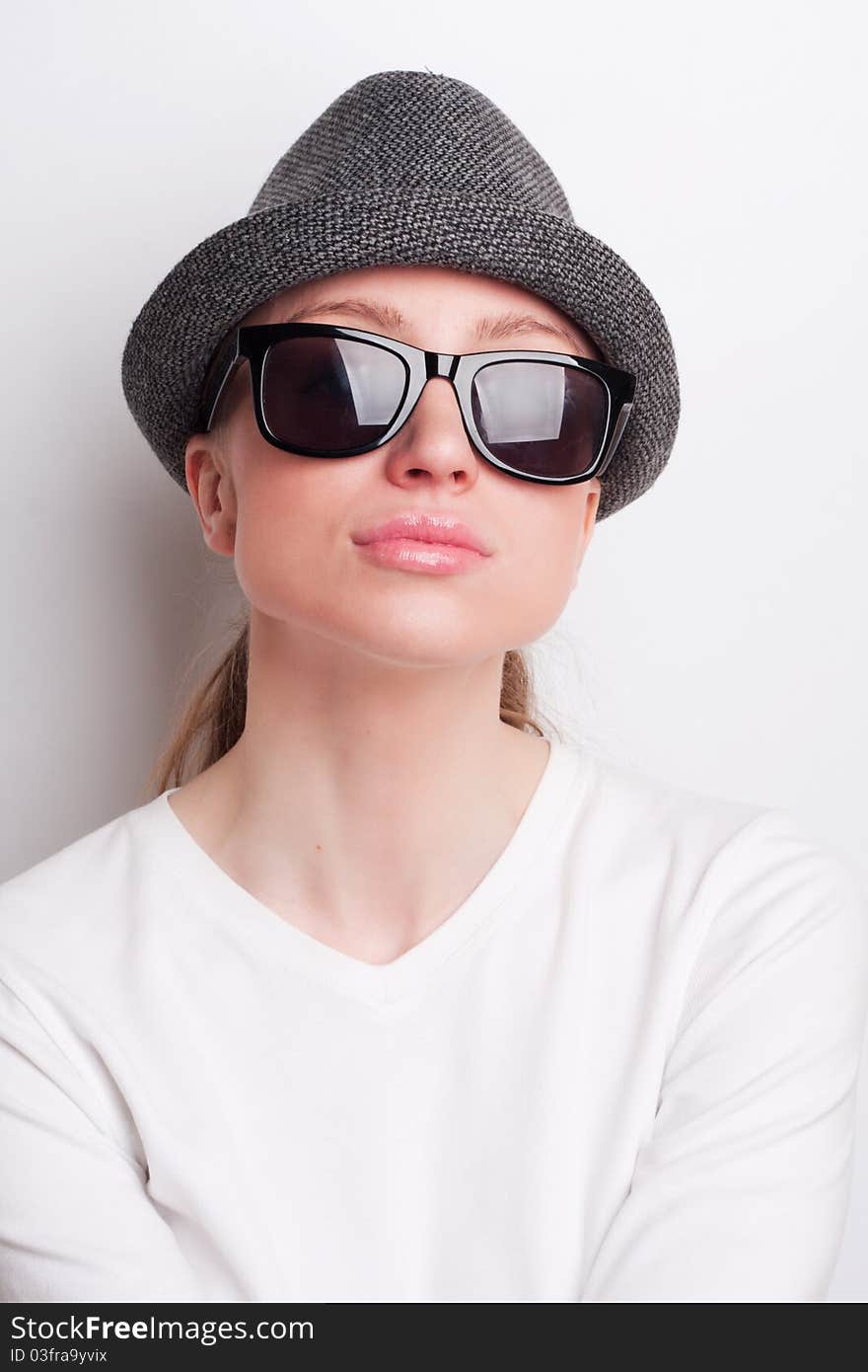 Retro photo of a girl in sunglasses and an old hat