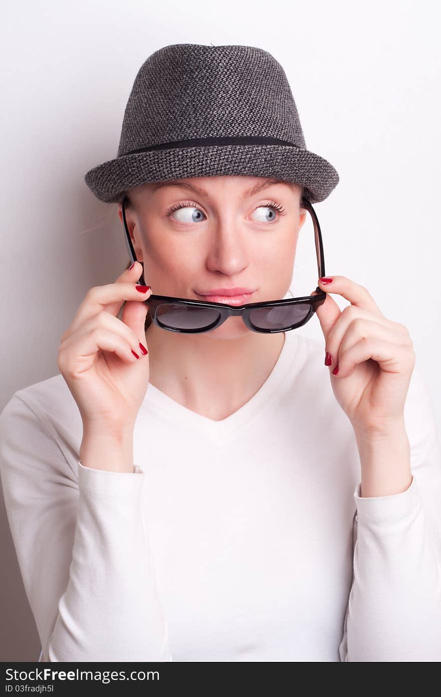 Retro photo of a girl in sunglasses and an old hat