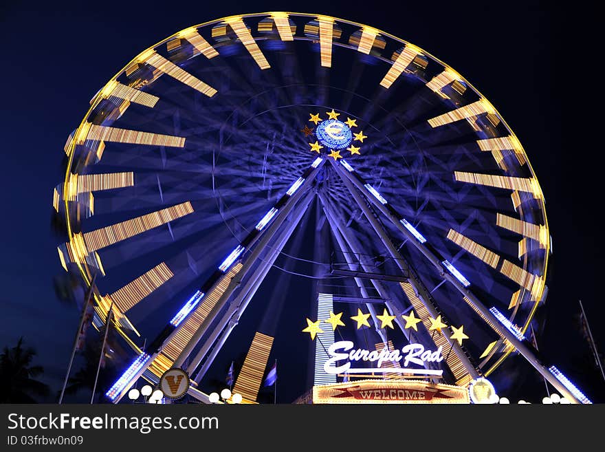 A Ferris wheel (also known as an observation wheel or big wheel) is a nonbuilding structure consisting of a rotating upright wheel with passenger cars (sometimes referred to as gondolas or capsules) attached to the rim in such a way that as the wheel turns, the cars are kept upright, usually by gravity.