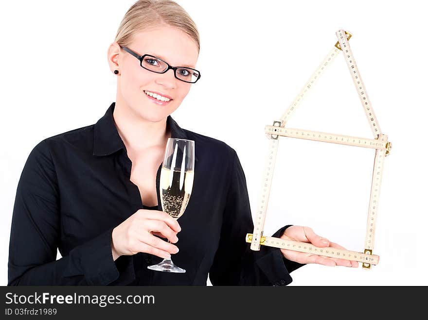 A young woman with folding rule as a house symbol and a champagne glass. A young woman with folding rule as a house symbol and a champagne glass