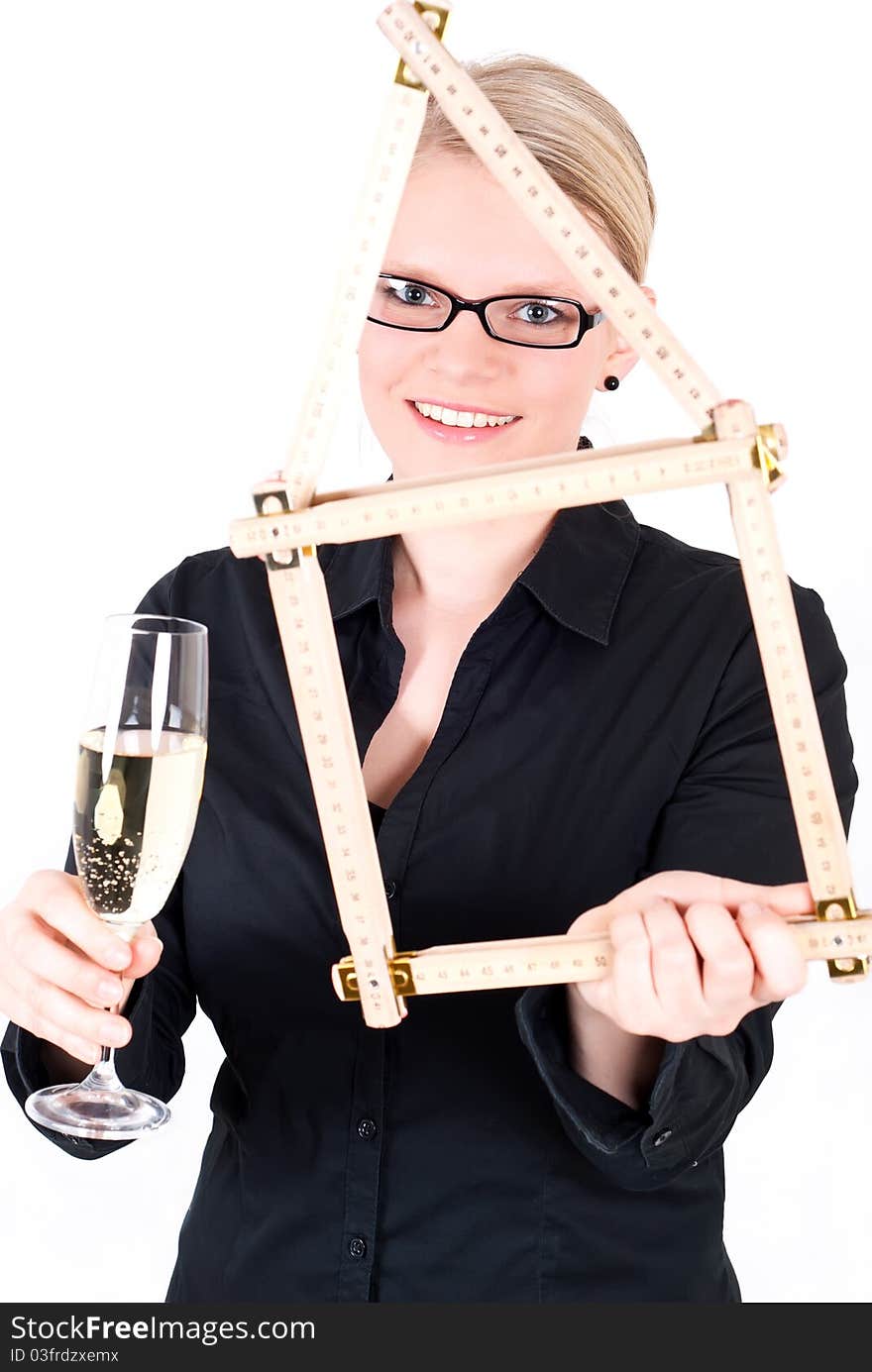 A young woman with folding rule as a house symbol and a champagne glass. A young woman with folding rule as a house symbol and a champagne glass