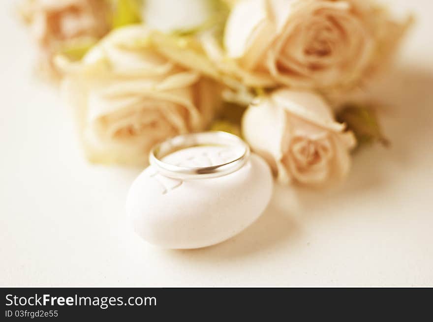 One silver ring and pink roses out of focus. One silver ring and pink roses out of focus.