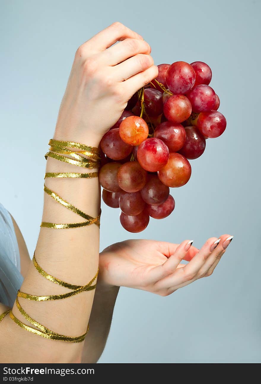 Bunch of grapes in the hands of a young woman