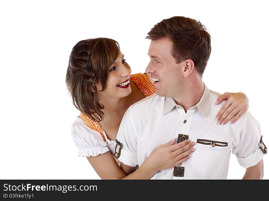 Bavarian Couple in love looks to each other and smiles. Isolated on white background. Bavarian Couple in love looks to each other and smiles. Isolated on white background.