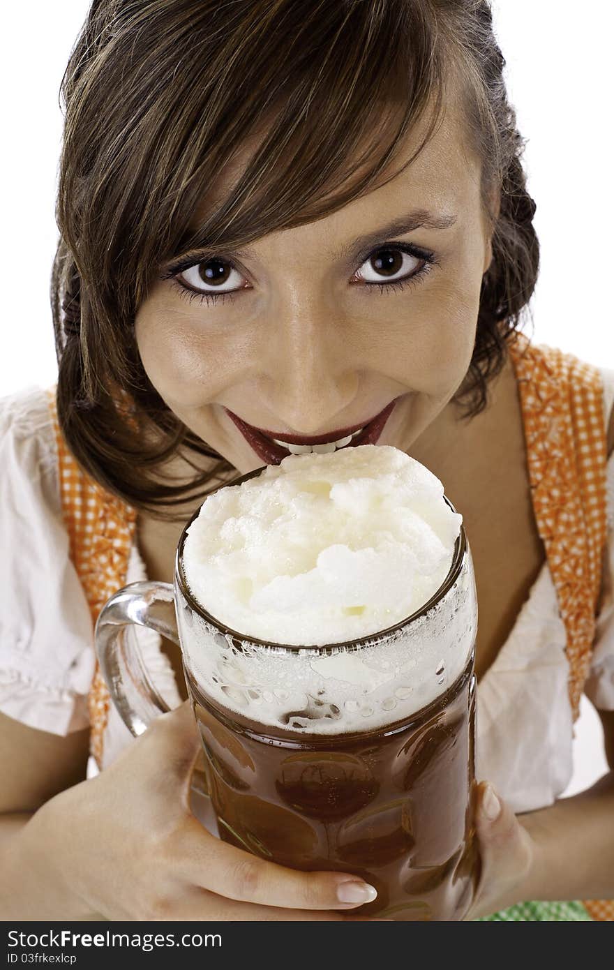 Young beautiful woman with dirndl drinks Oktoberfest beer stein.Isolated on white background.