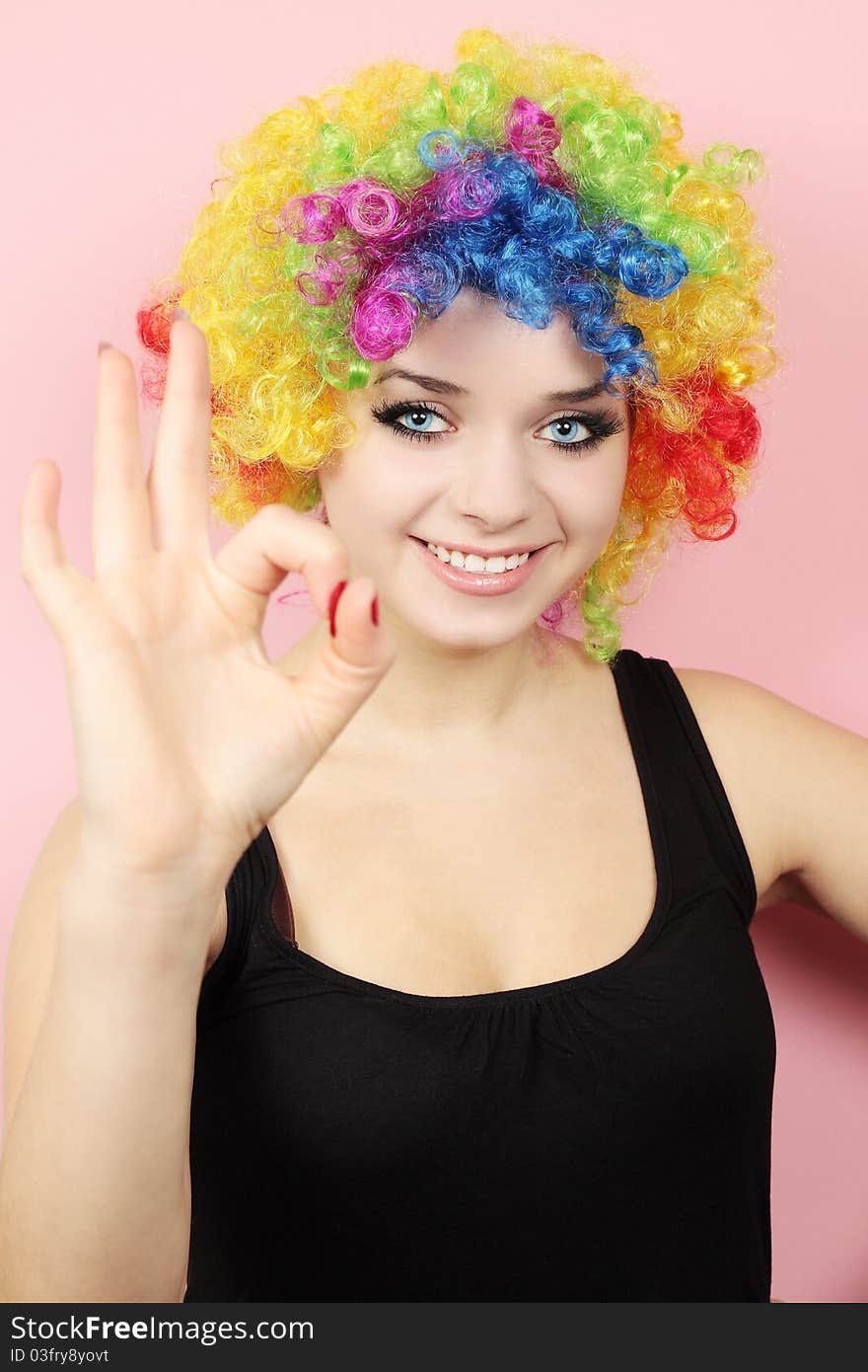 Woman in the clothing of clown shows to the okay