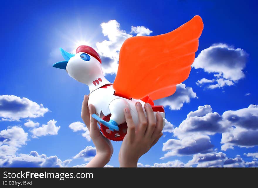 Childrens hands hold a toy against the blue sky. Childrens hands hold a toy against the blue sky.