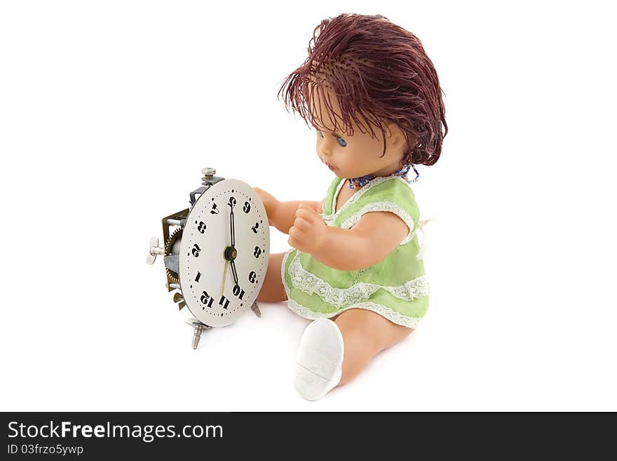 The doll repairing an ancient alarm clock. It is isolated on a white background.