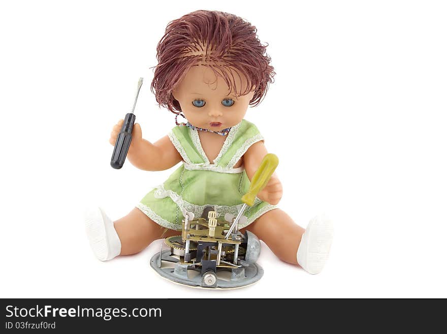 The doll repairing an ancient alarm clock. It is isolated on a white background.