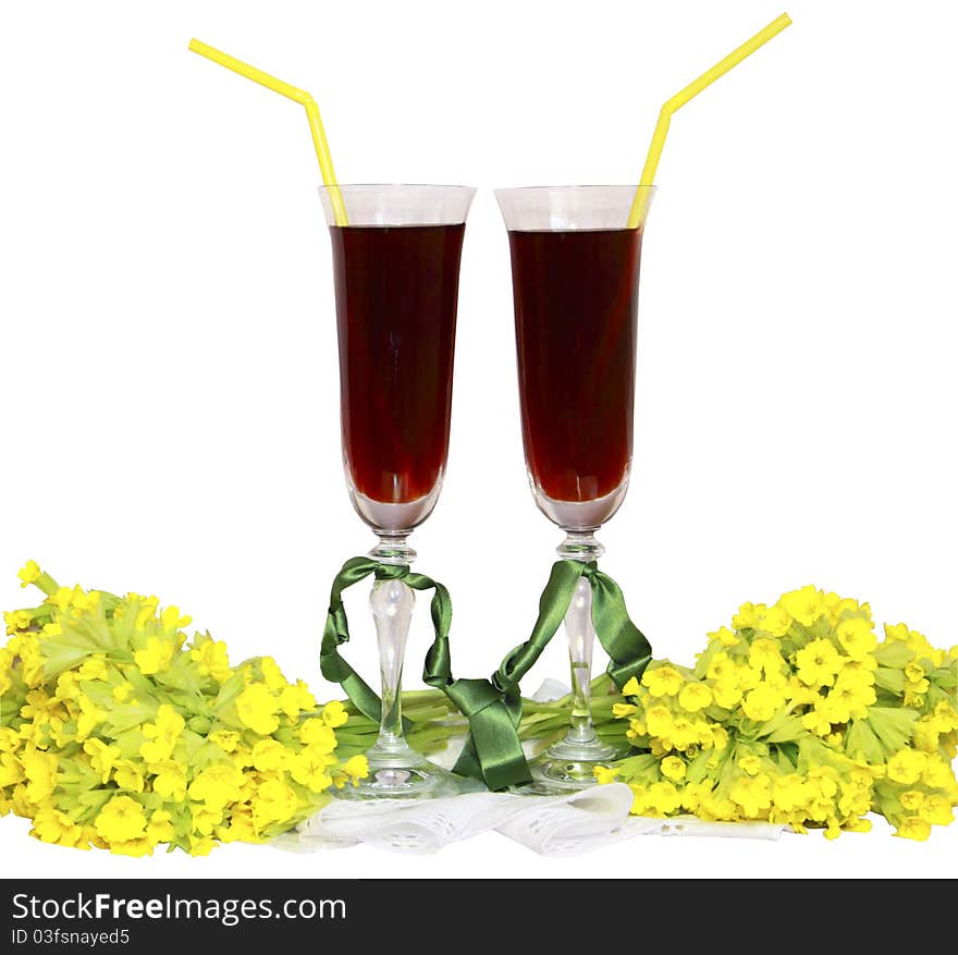 Two glass glasses with wine tubes for a cocktail and bouquets yellow field flowers