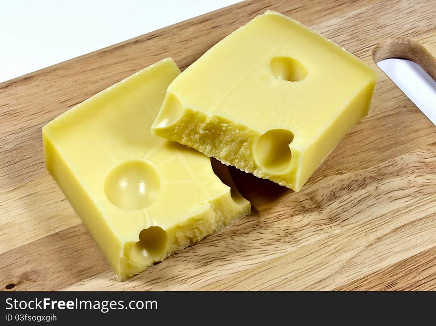 emmental cheese split in half on a wooden board