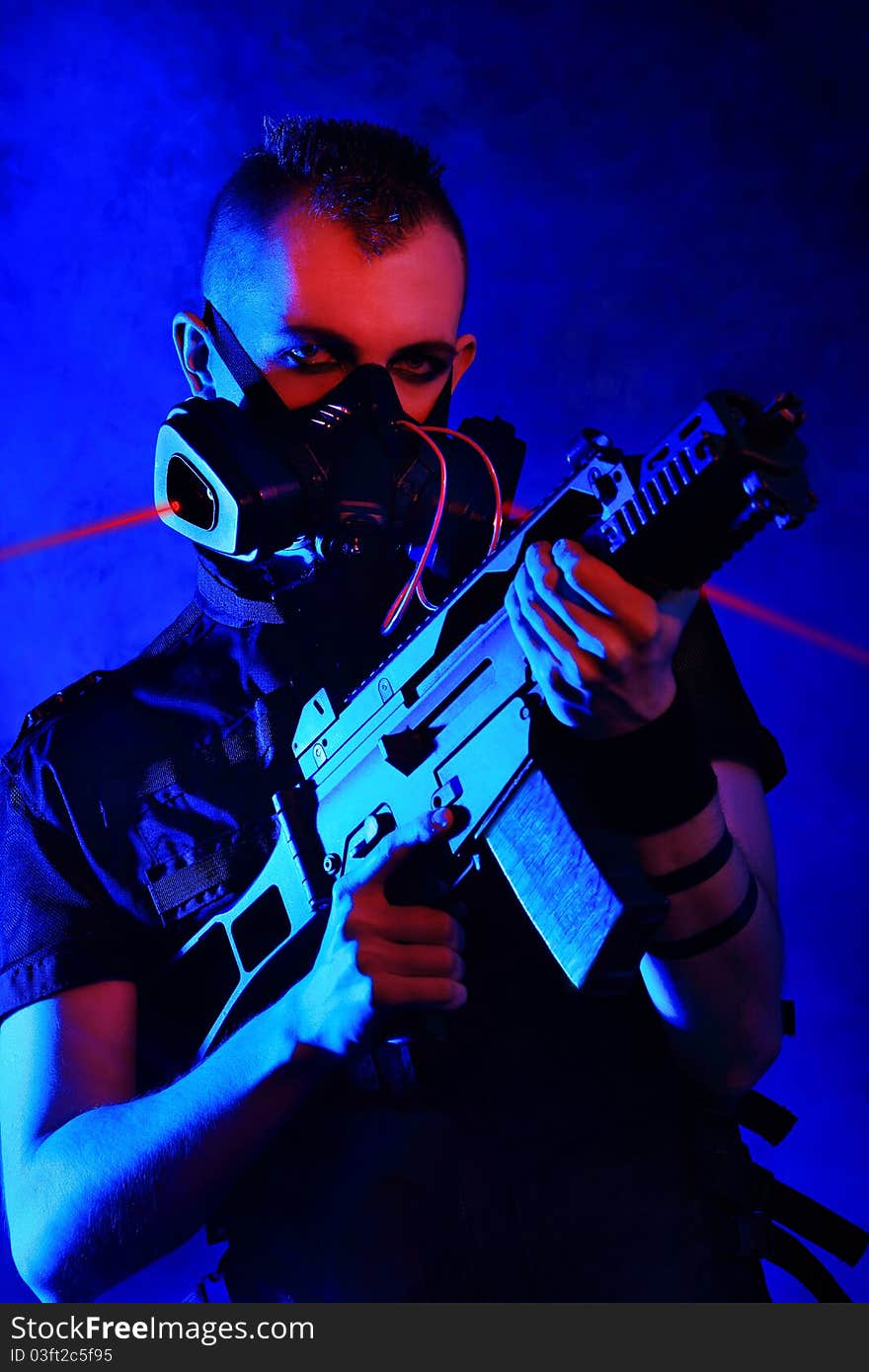 Shot of a conceptual man in a respirator holding a gun. Shot of a conceptual man in a respirator holding a gun.