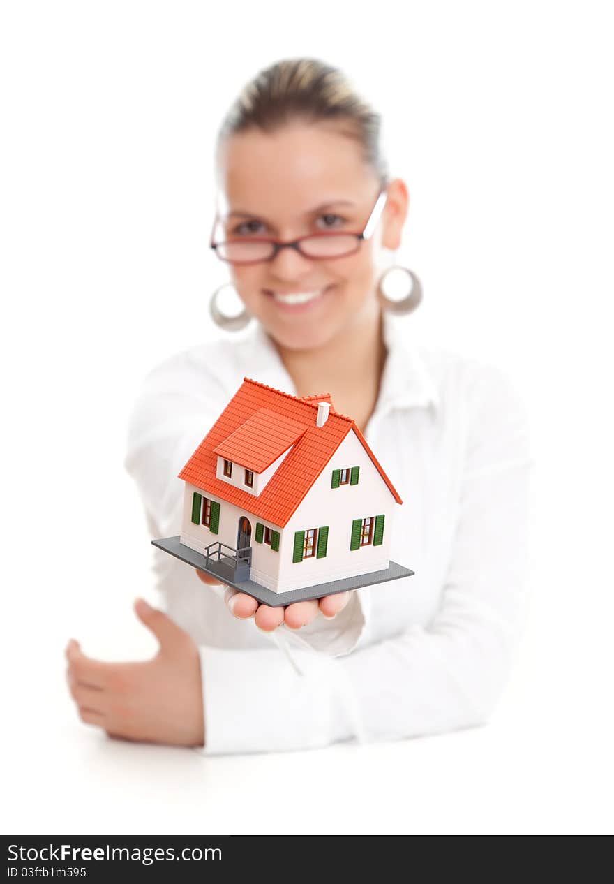 Attractive woman offering a miniature house to us, focus on the house. Attractive woman offering a miniature house to us, focus on the house