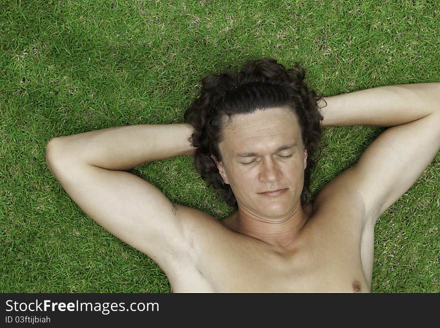 The man lies on a green grass