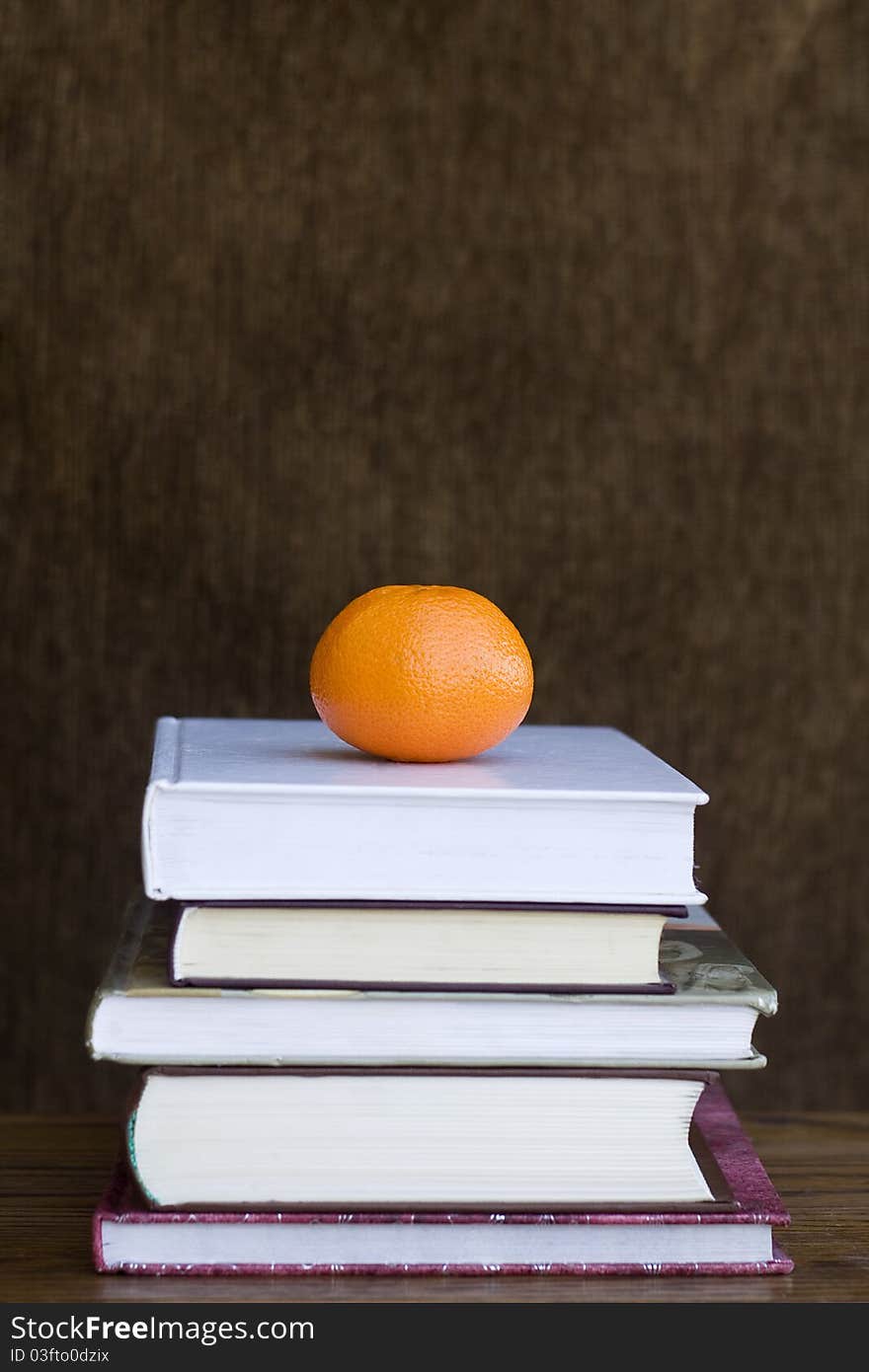 An orange on the pile of books