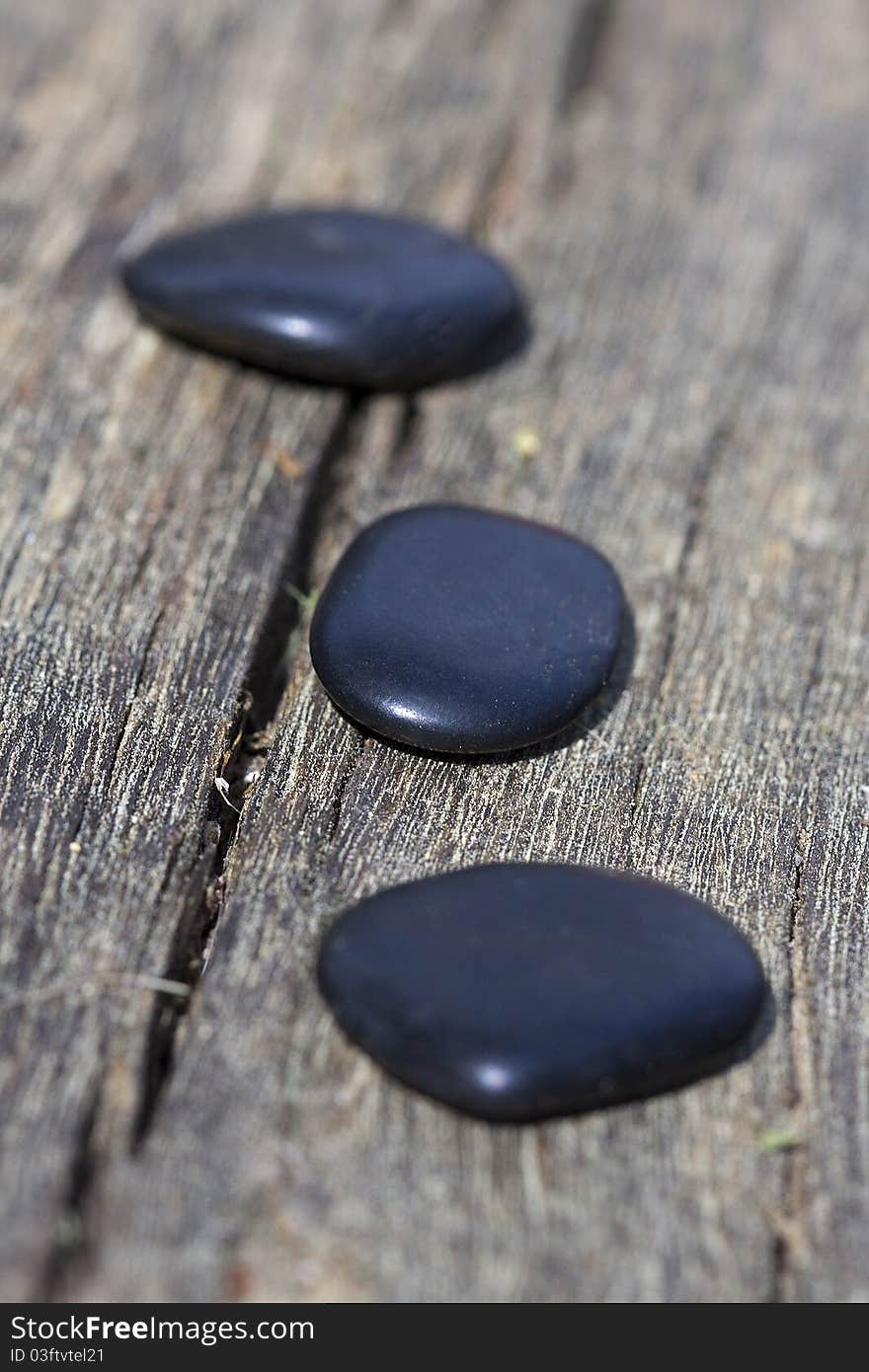 Three black stones with old wooden background. Three black stones with old wooden background